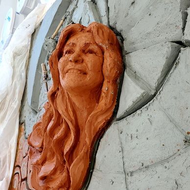 Illustrated is the insertion of a clay head portrait into the stoneware relief mural.