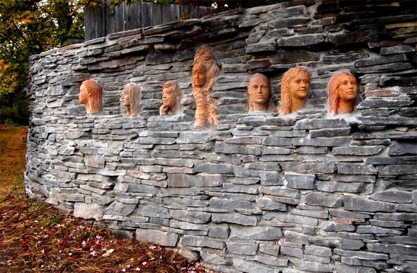 Ceramic clay portraits embedded in a bluestone wall
