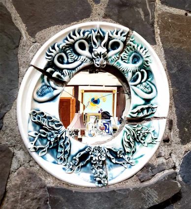 A porcelain dragon art mirror set into a stone wall