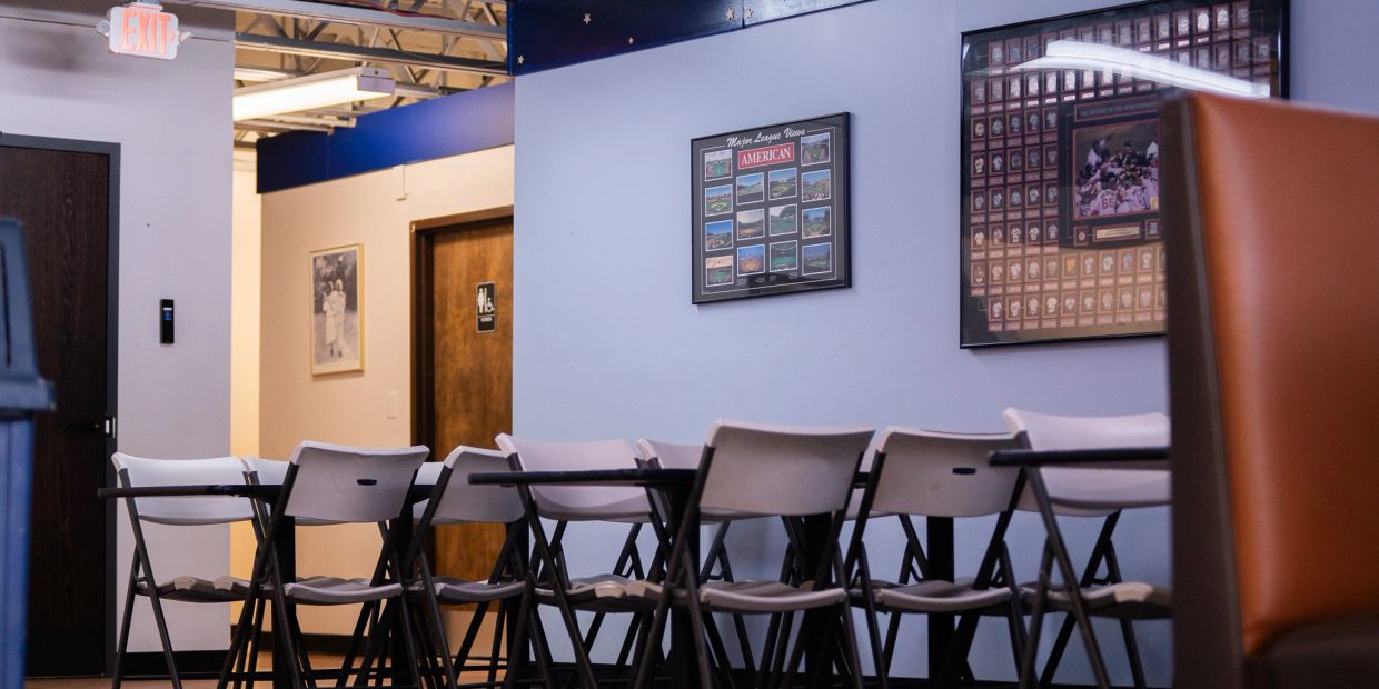 Empty conference room with folding chairs and framed pictures.