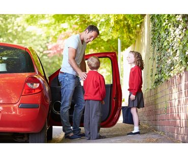 Childcarer efficiently picking children up from school.