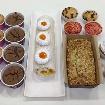 Assorted baked goods including muffins, cake roll, and loaf bread.