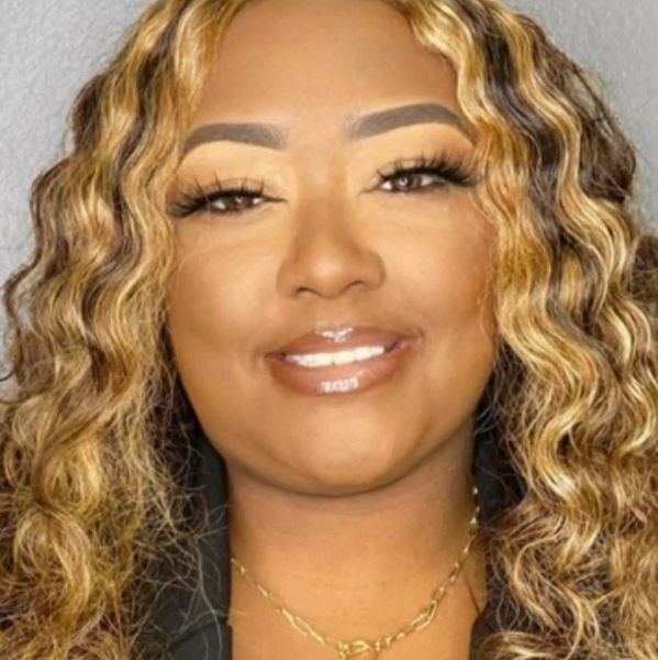 Woman with curly blonde hair and glossy lips.