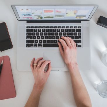 Woman's hands typing on a laptop.
