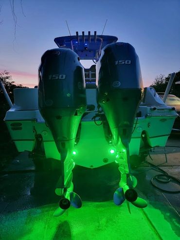 A view of the Rear of the boat shows both 150 horsepower engines and green underwater lights.