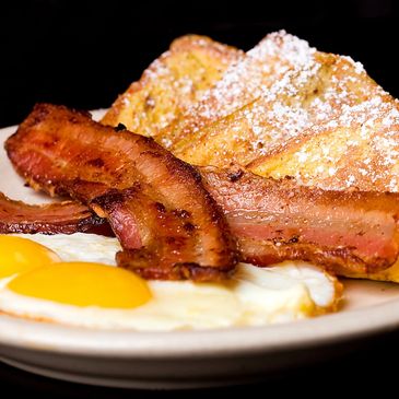 Eggs Sunny Side Up with Bacon or Sausage and French Toast covered in Maple Syrup