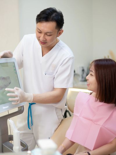 Dentist explaining dental X-ray to patient in clinic.