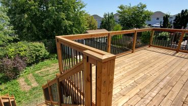 pressure treated deck with wooden railings and aluminum spindles. located in Bowmanville, Ontario.