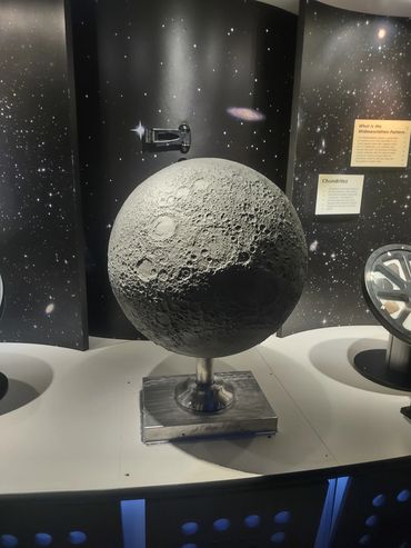 Detailed moon model showcased in a space-themed exhibit.