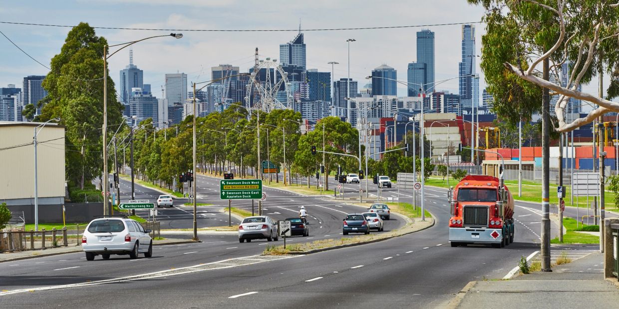 Urban road with light traffic and city skyline.