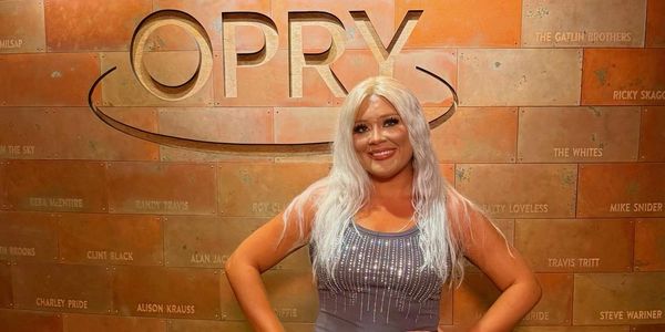 Woman posing in front of OPRY sign.