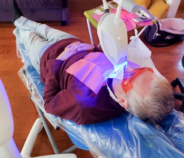 Man laying on mobile dental chair during At-Home Philips Zoom teeth whitening, VitaliTeeth Dental