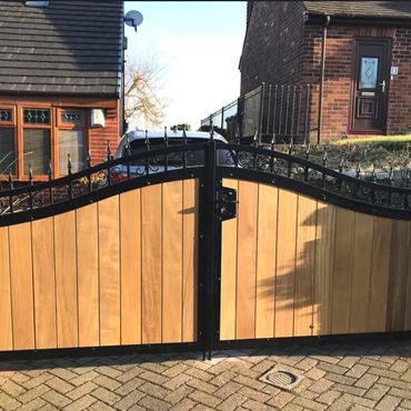 Bespoke made to measure driveway gate with wood panels and black iron frame