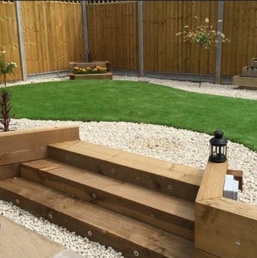 Neatly landscaped garden with wooden steps and green lawn.