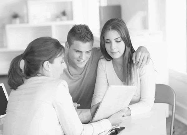Couple reviewing documents with a professional in an office setting.