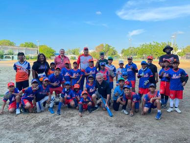 Youth baseball team with coaches posing on field.