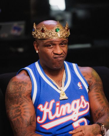 Man wearing a blue Kings basketball jersey and a golden crown.