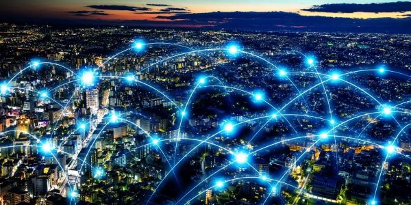 Cityscape at night with glowing blue digital network connections overlay.