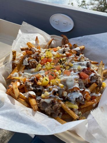 Loaded fries topped with cheese, grilled corn, diced tomatoes, and creamy sauce.