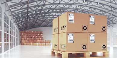 Stacked cardboard boxes on a wooden pallet inside a spacious warehouse.