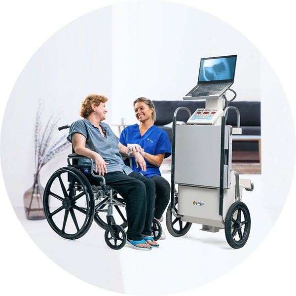 A nurse assists a patient in a wheelchair with medical equipment nearby.