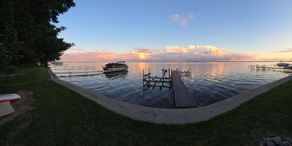 Calm lake at sunset with docks and boats.