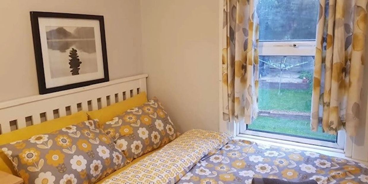 A bedroom with yellow flowery bedsheets and curtains