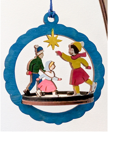 Platform style wood ornament with 3 children ice skating.  Hand painted in bright colors.