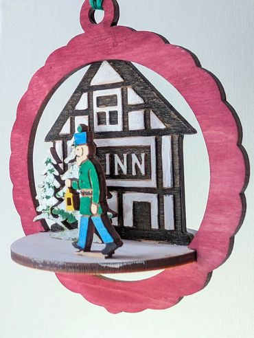 Platform style wood ornament with a 1800's miner walking home from work passing the village inn.