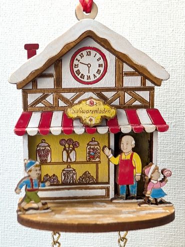 Tiny cuckoo clock ornament with Candy Shop, the candy maker waving to the running children.
