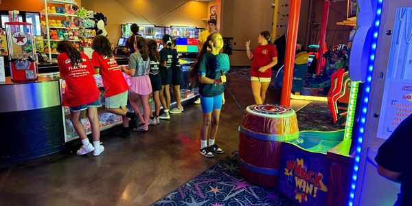 Kids playing games and enjoying snacks at an arcade.