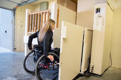 Vertical platform lift for wheelchair in a garage.