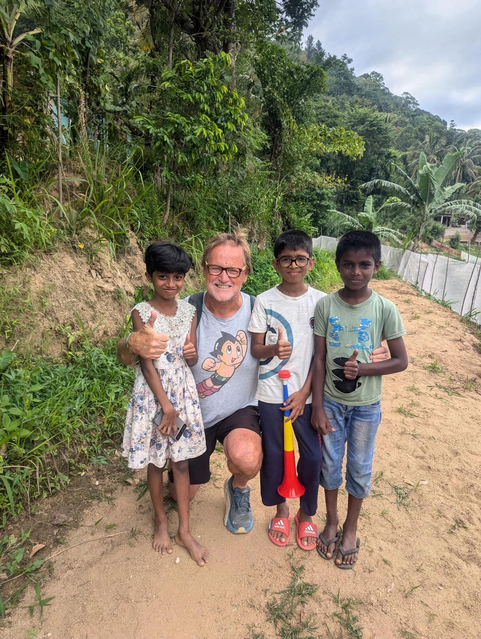 Standing in Sri Lanka rice paddies with Walapane school kids, thumbs up for a bright new future