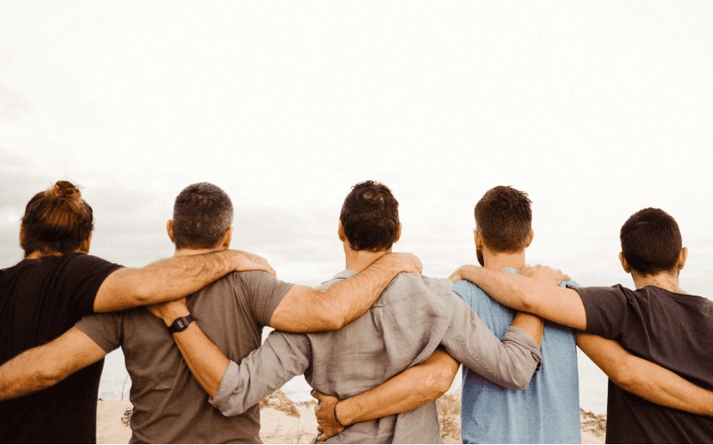 Men standing shoulder to shoulder on the NSW South Coast . A raw moment of connection and reset
