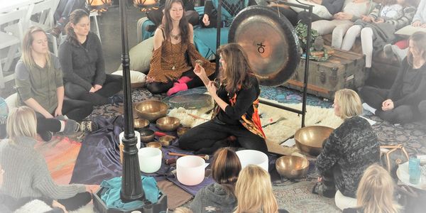 Ann Martin playing singing bowls and gong at meditative gathering