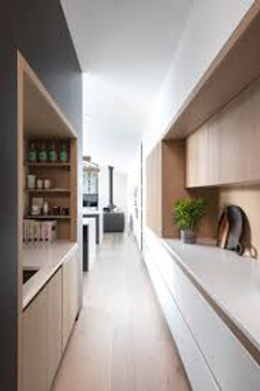 Modern kitchen with light wood and white cabinetry.