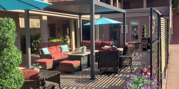 Outdoor patio with red cushioned seating and blue umbrellas.