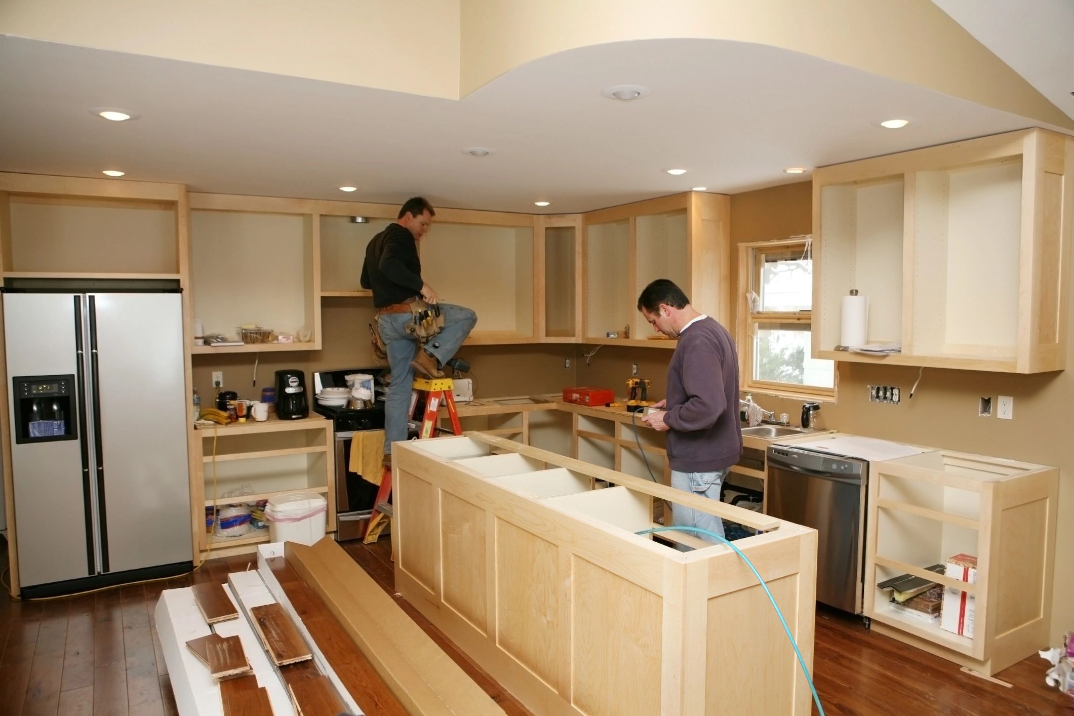 Cabinet maker installing custom made kitchen island and cabinets