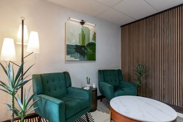 Modern seating area with green chairs and marble table.