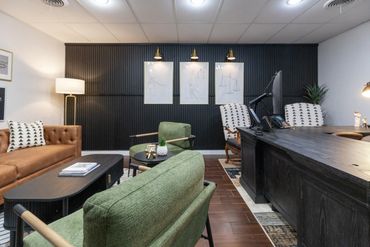 Modern office with stylish seating and dark accent wall.