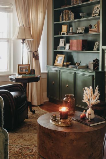 Cozy living room corner with warm lighting, candles, and classic decor.