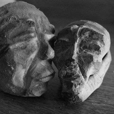 Detail of faces carved on avocado pits