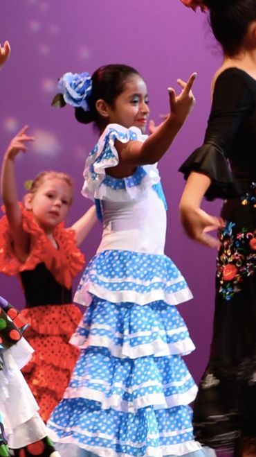 Image of children's group performing on stage "Rumba" a traditional Flamenco dance