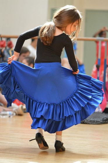 Student in children's dance class practicing their skirt movement and Flamenco footwork