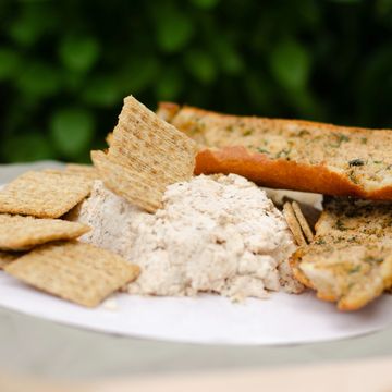 Plate with crackers and a creamy dip, garnished with herbs.