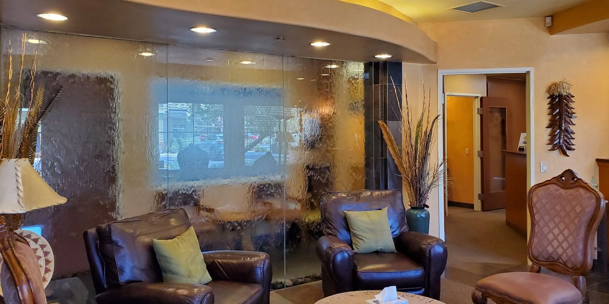 Cozy waiting area with leather chairs and decorative glass wall.