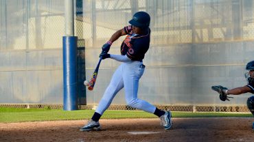 Baseball player hitting a pitched ball during a game.