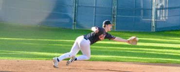 Baseball player diving to catch a ball on the field.