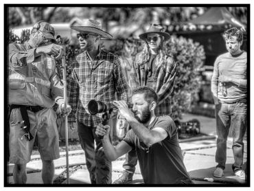 Crew working together on a film set outdoors in black and white.