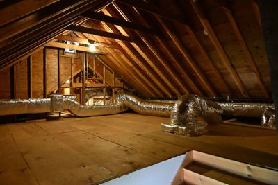 Spacious attic with exposed wooden beams and ductwork.